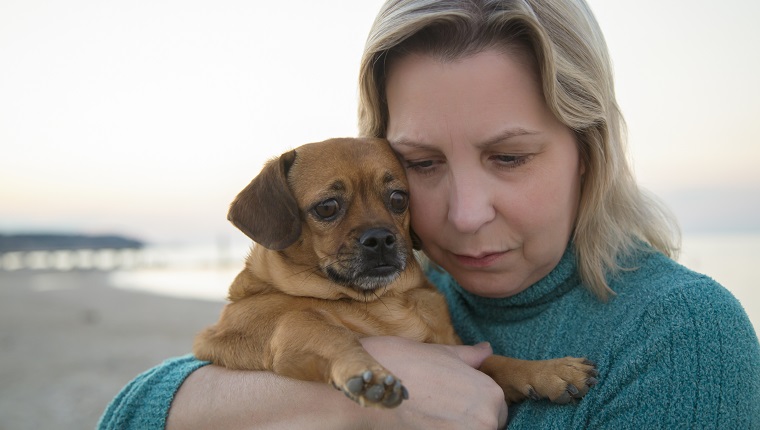 Woman with her dog during a sunset.