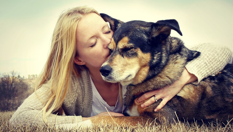 Woman Tenderly Hugging and Kissing Pet Dog