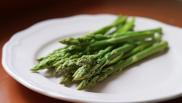 Healthy summer vegetable: Green aspargus on white plate.