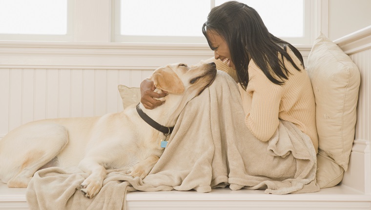 African woman hugging dog