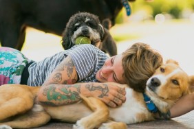 Tattoed woman relaxing with dogs at the park