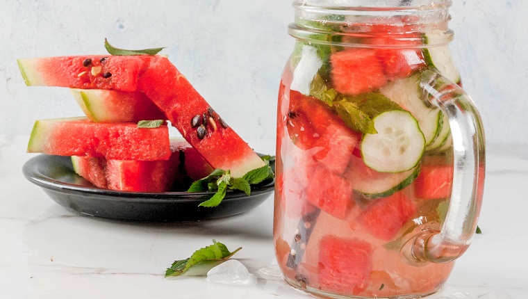 Summer drinks and cocktails. Lemonade, infused detox water with mints, fresh watermelon and cucumber. In mason jar, on a white marble table. Copy space