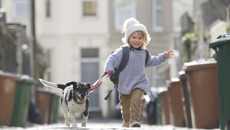 Young child running with dog