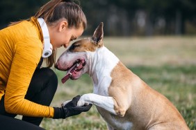 Woman doing exercises outdoors with her dog