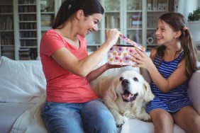 Happy mother checking the surprise gift given by her daughter at home