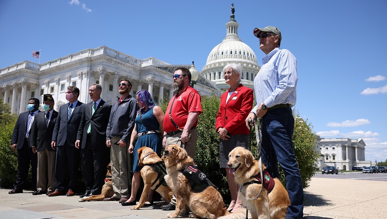 WASHINGTON, DC - MAY 13: Military service dogs and their handlers with K9s for Warriors pose for a photo after press conference for H.R. 1448, Puppies Assisting Wounded Service Members (PAWS) for Veterans Therapy Act outside the U.S. Capitol Building on May 13, 2021 in Washington, DC. The legislation was drafted to help start a program to promote the use of service dogs as a form of therapy for military veterans. 