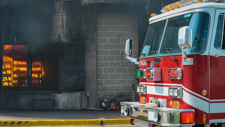 Fire and smoke at a burn building with a fire truck in front