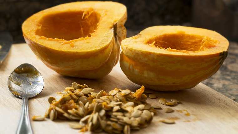 Winter squash cut in half with spoon and seeds scooped out.