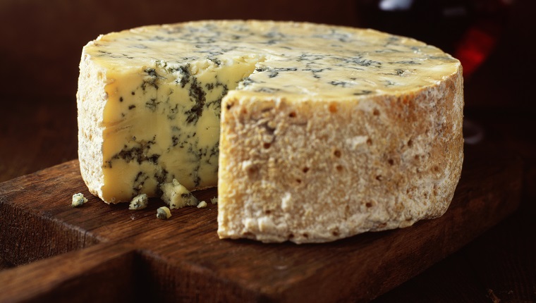 Blue cheese round on wooden cutting board