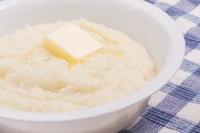 A bowl of white corn grits on a blue plaid placemat