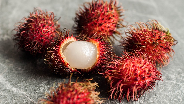 Still life close-up of ripe rambutan fruit on a marble kitchen table