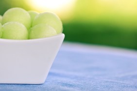 Honeydew melon balls in a white porcelain dish.