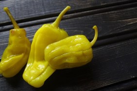 Pepperoncini peppers on a rustic, wooden background.