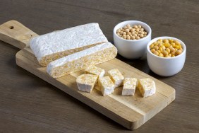 Indonesian, fermented soybeans cake, tempeh, for a plant based vegetarian diet on a wooden board