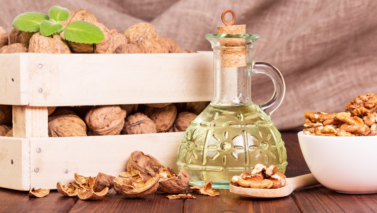 Walnut oil and nuts in a box on a background of burlap