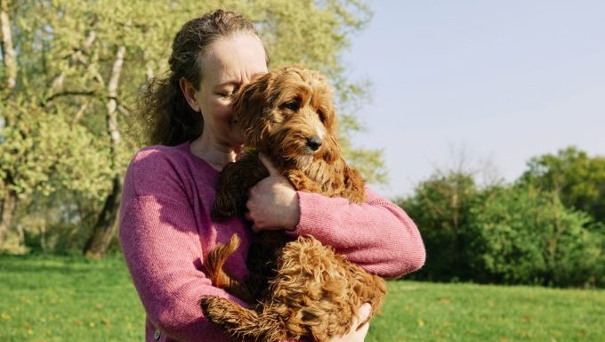 woman hugging dog springtime pet care tips