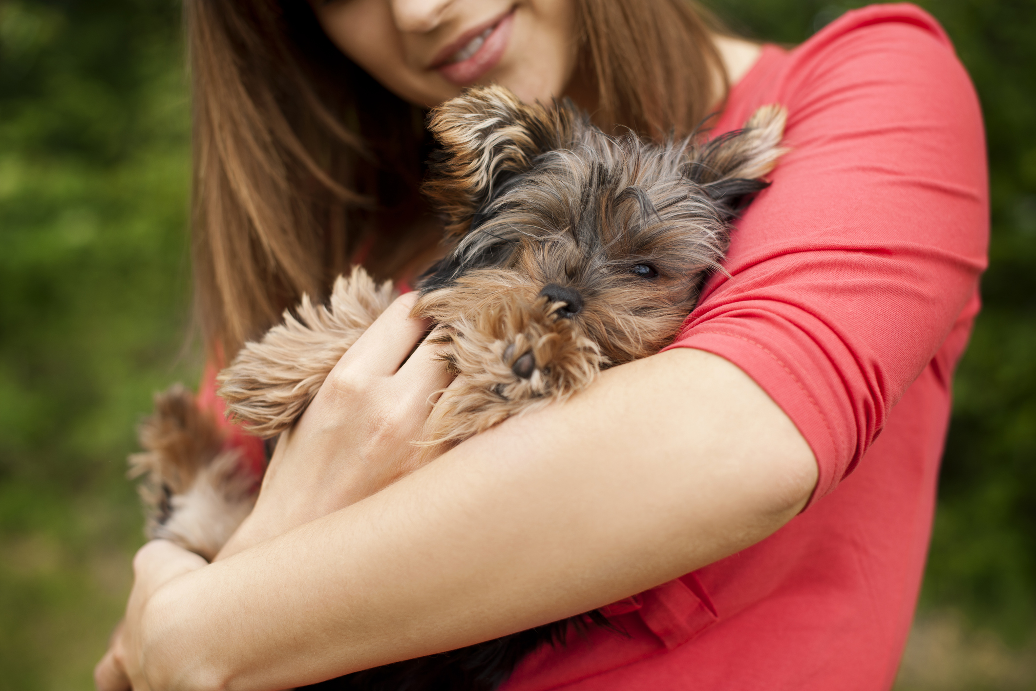 woman hugging small dog rescued from car engine