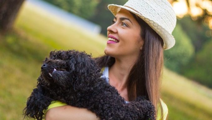 woman hugging poodle best dog breeds for a pisces