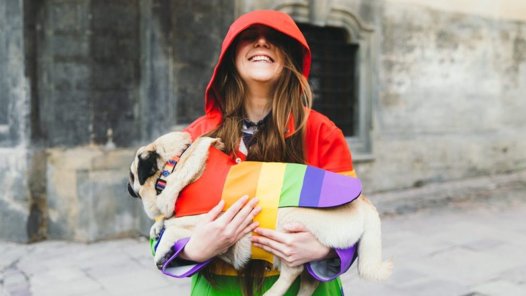 woman and pug in rainbow clothing celebrate pride month with your dog