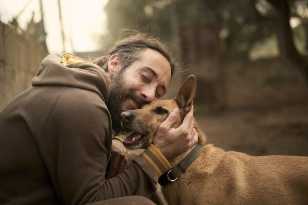 An owner hugging his dog, similar to the Chicago restaurant owner who hosted a fundraiser at his restaurant in tribute to his dog who had cancer.