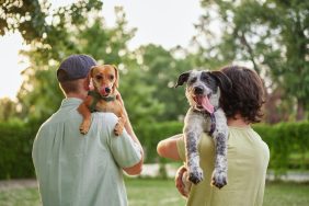 A couple carrying their two dogs, like the couple with a dog who overdosed on Opioid medication in Kentucky.