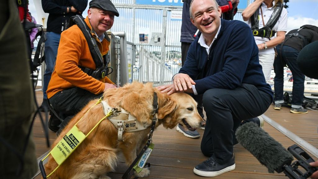 Leader of the Liberal Democrats Ed Davey meets Steve Darling, Liberal Democrat candidate for Torbay and his guide dog Jennie before going sailing with the Disabled Sailing Association at Torquay Harbour, on June 11, 2024 in Torquay, England.