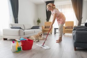 Woman mopping the floor with pet safe cleaning products and disinfectants that won't harm her dog.