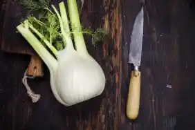 A fennel bulb on a wooden cutting board.