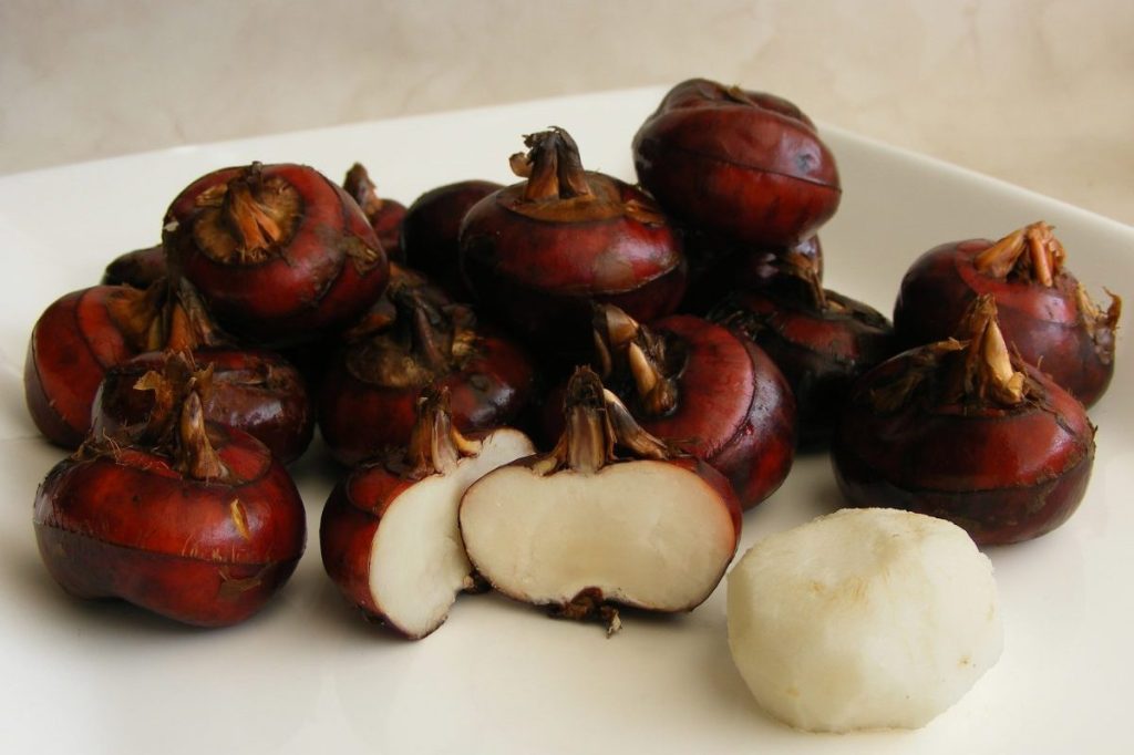 Fresh water chestnuts on a board.