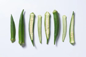 Sliced okra, which is safe for dogs to eat, against a white background.