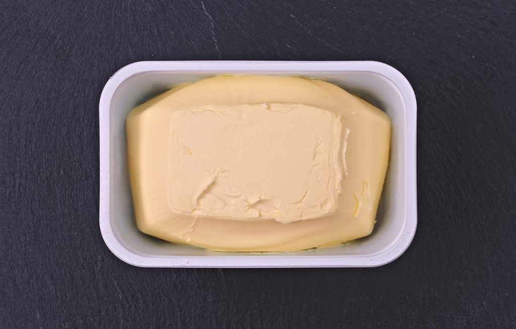 Just opened margarine box on a plate of slate.